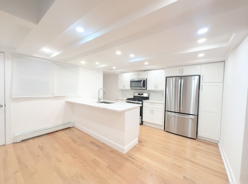 a kitchen with white cabinets and stainless steel appliances