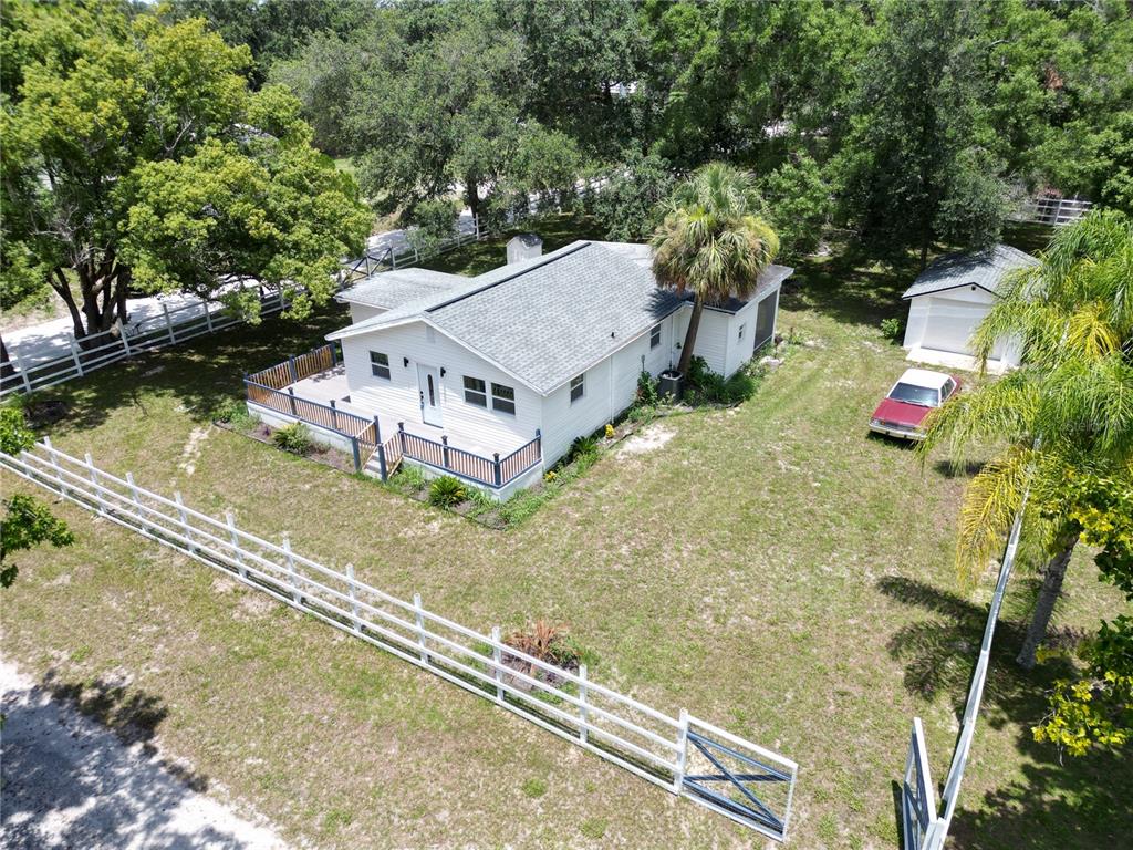 a aerial view of a house with swimming pool and large trees