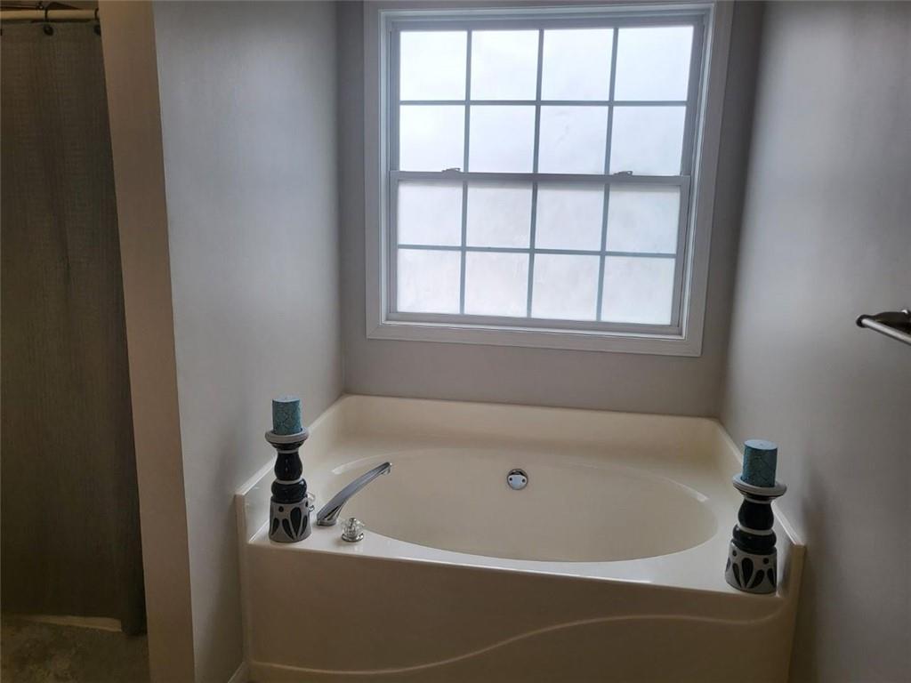 a white bath tub sitting in a bathroom next to a window