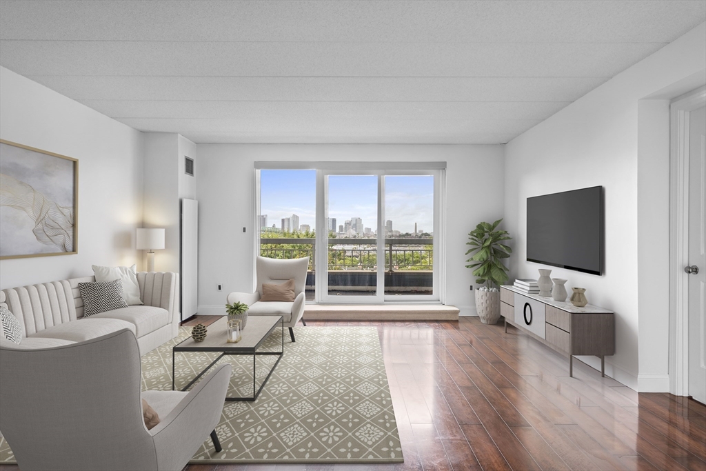 a living room with furniture a flat screen tv and a large window