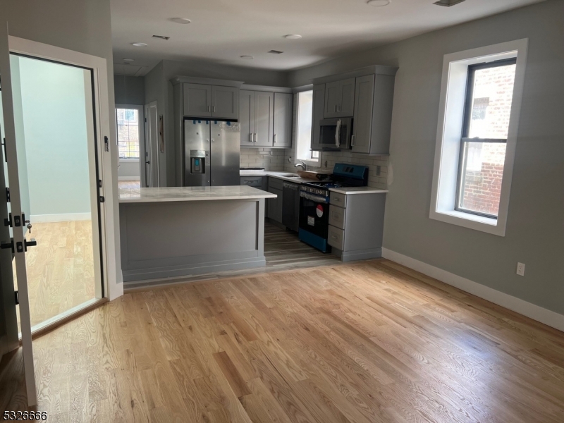 a kitchen with granite countertop a refrigerator stove and sink