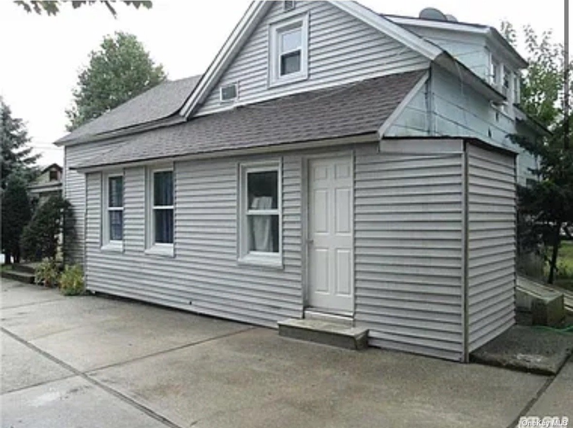 a view of a white house with a small backyard