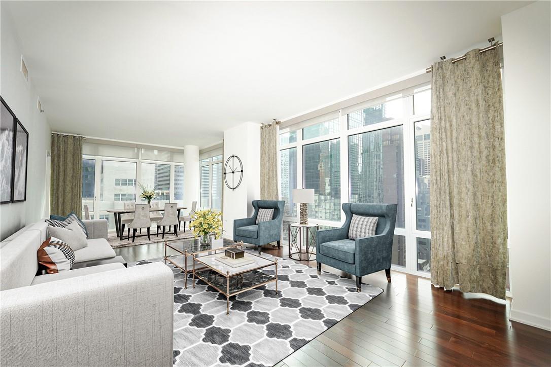 a living room with furniture large window and wooden floor