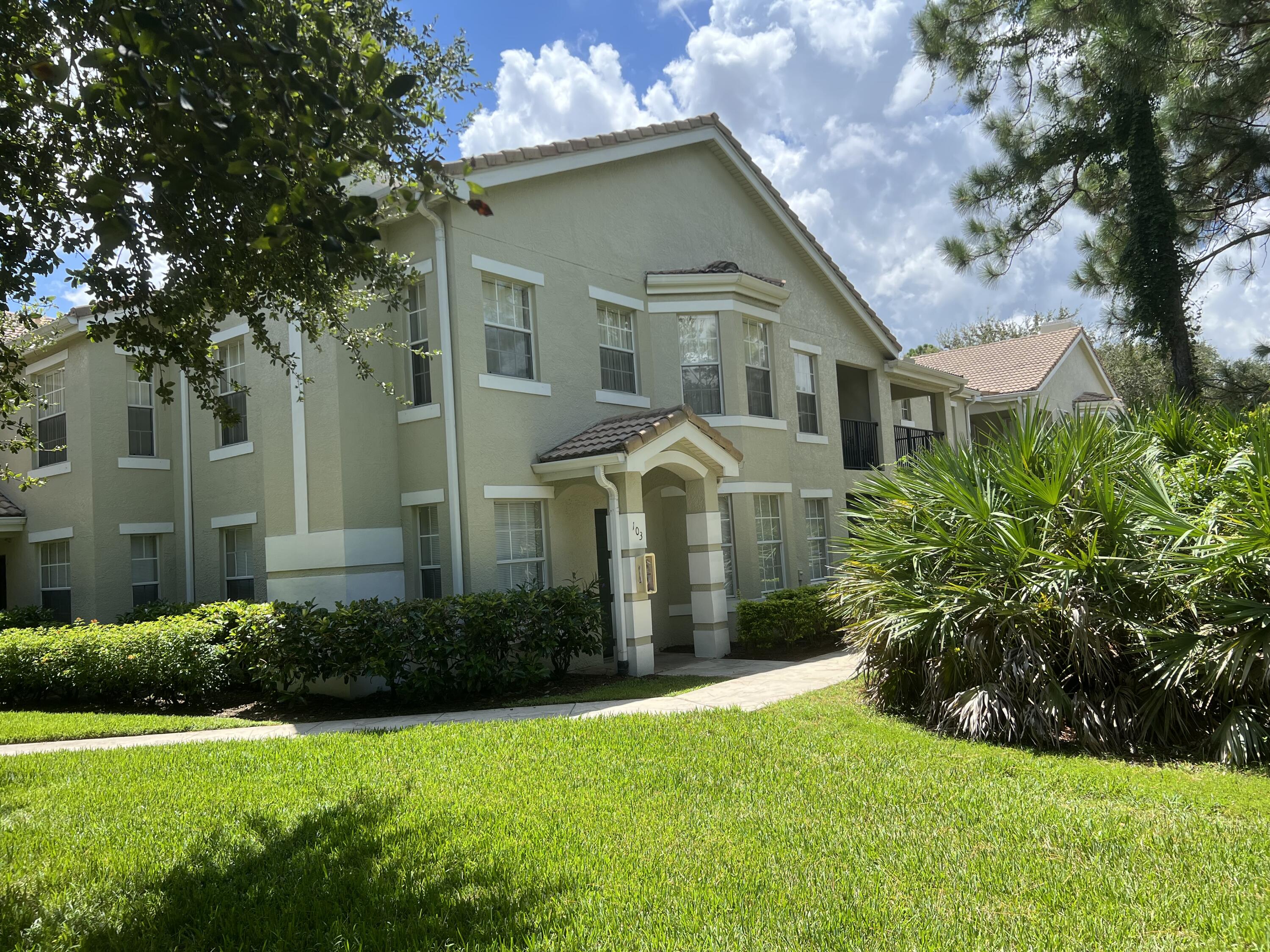 a front view of a house with yard and green space