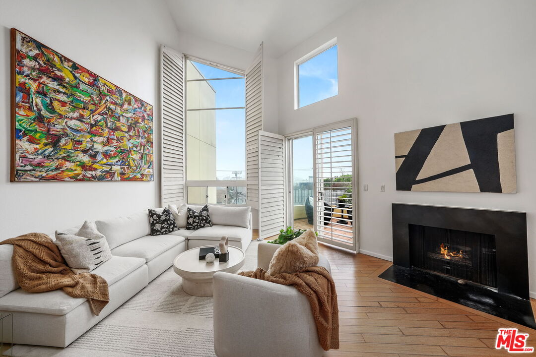 a living room with furniture a fireplace and a large window