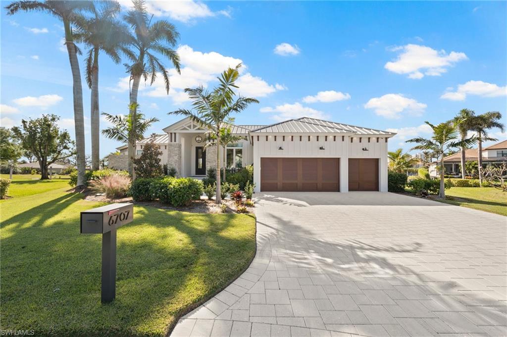 View of front of house with a garage and a front yard