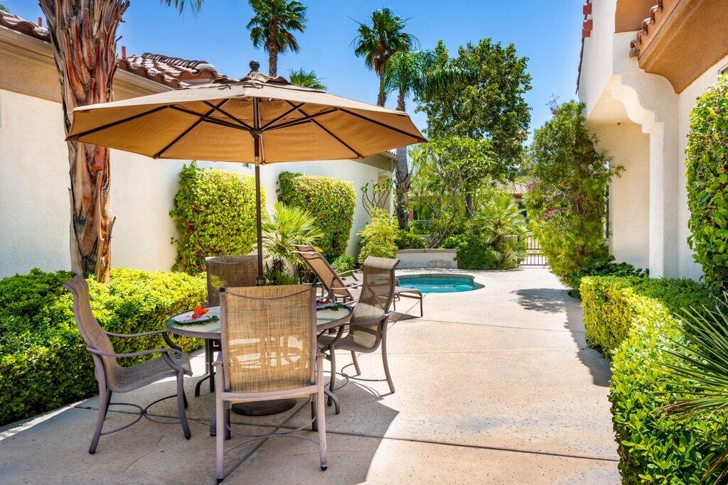 a view of a patio with a table and chairs under an umbrella