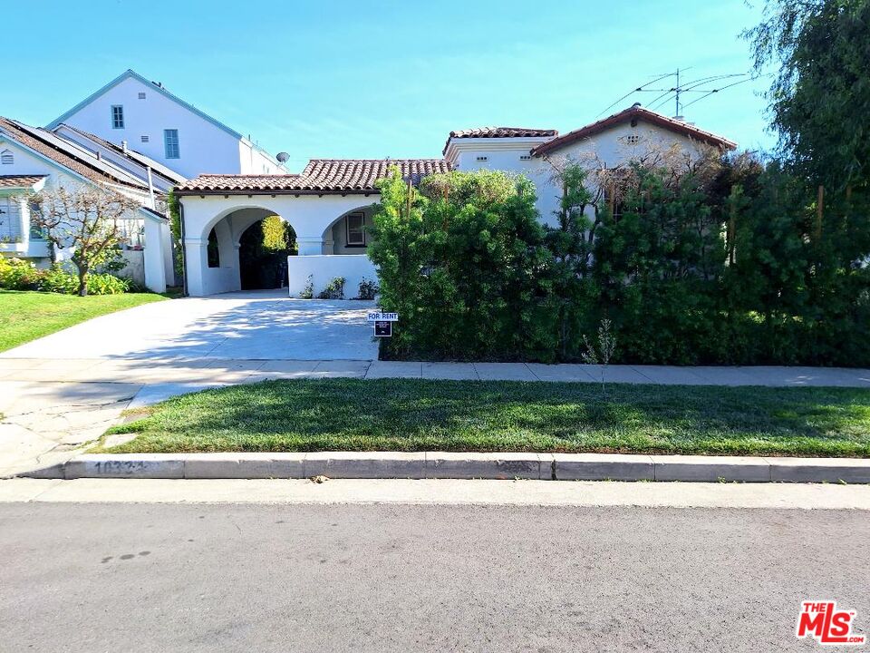 a front view of a house with a garden and plants