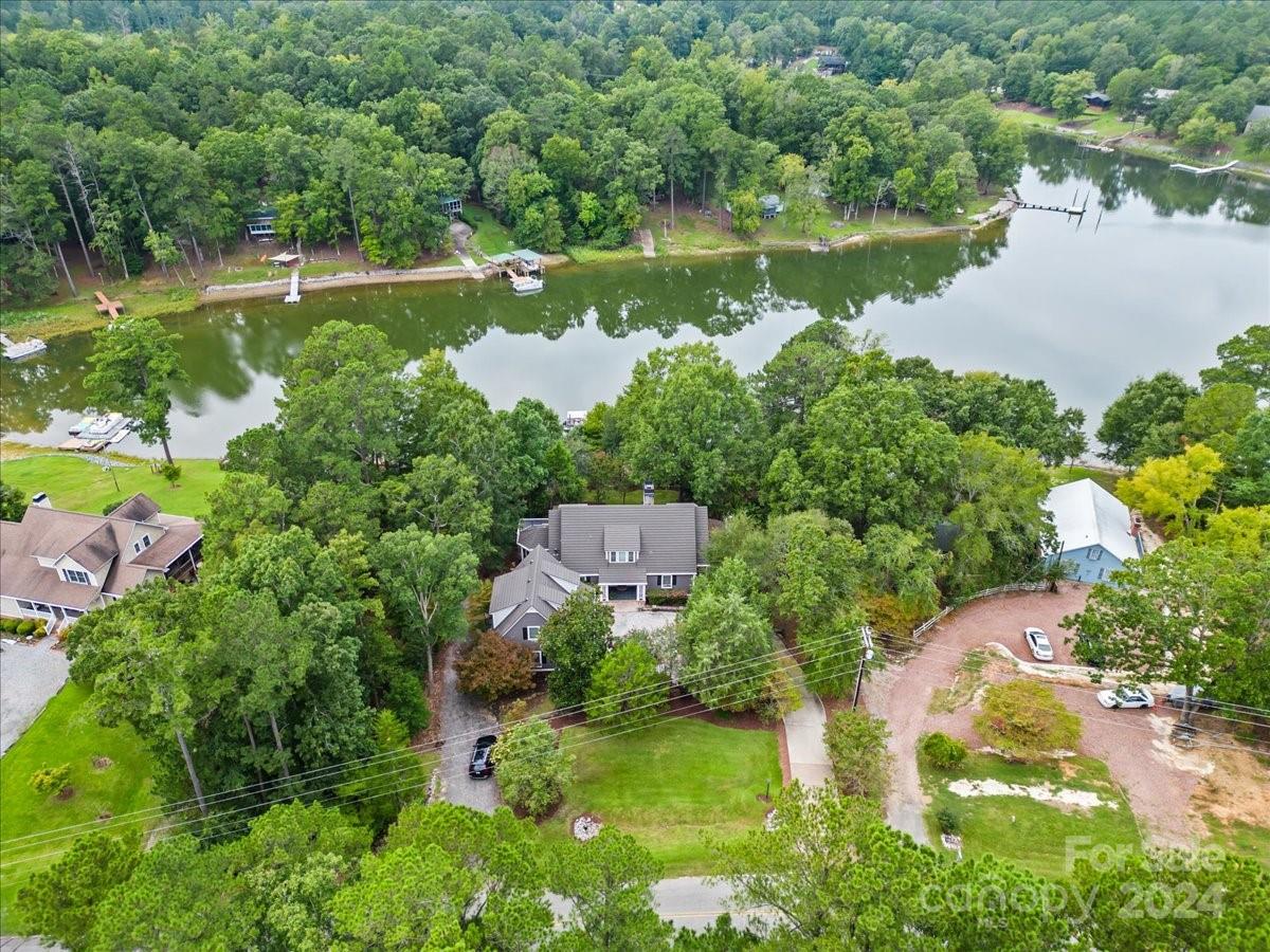 an aerial view of a house with a yard and lake view