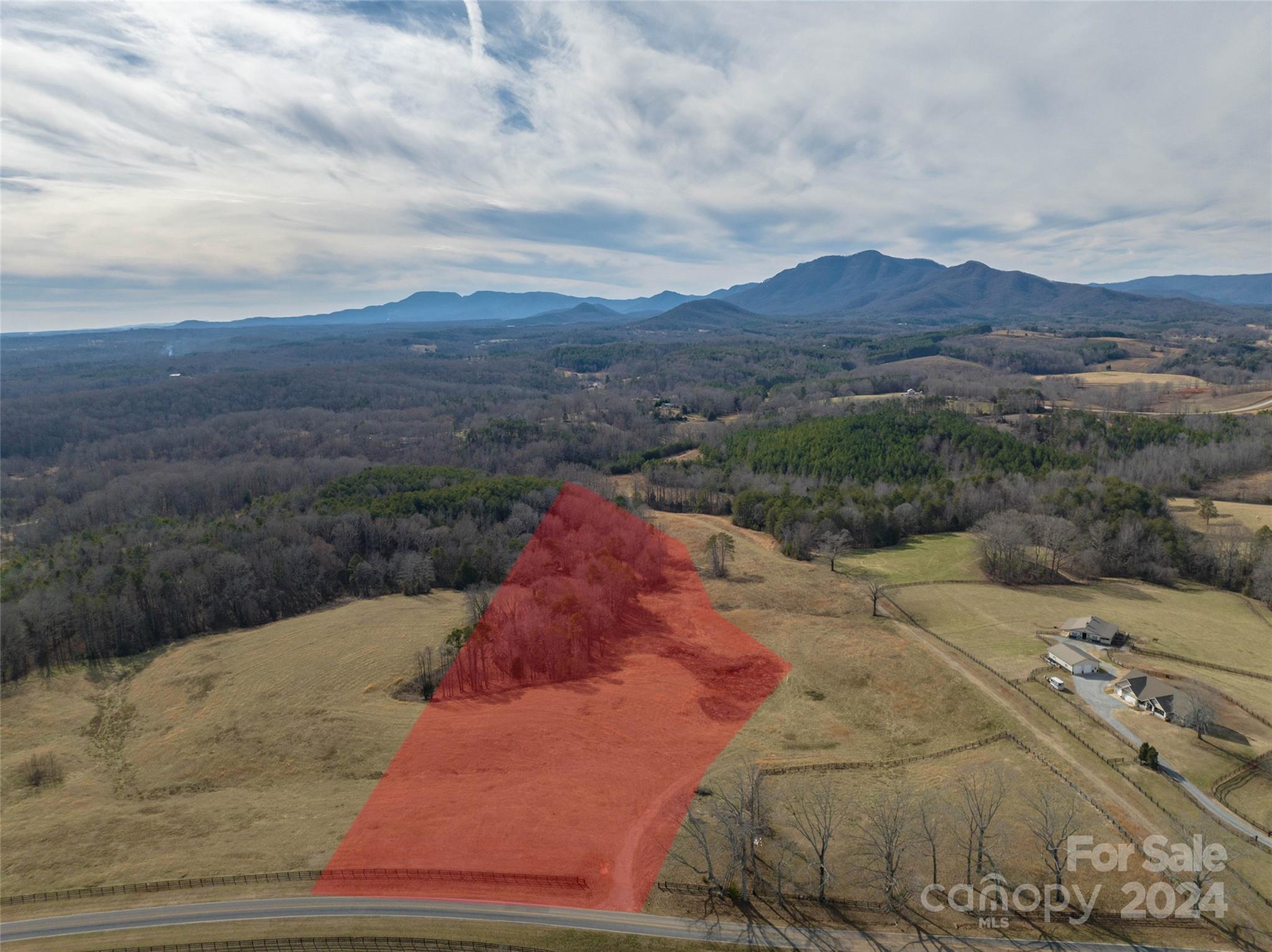 a view of a dry yard with mountains in the background