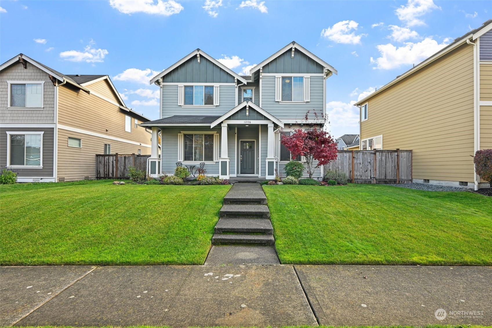 a front view of a house with a yard and potted plants