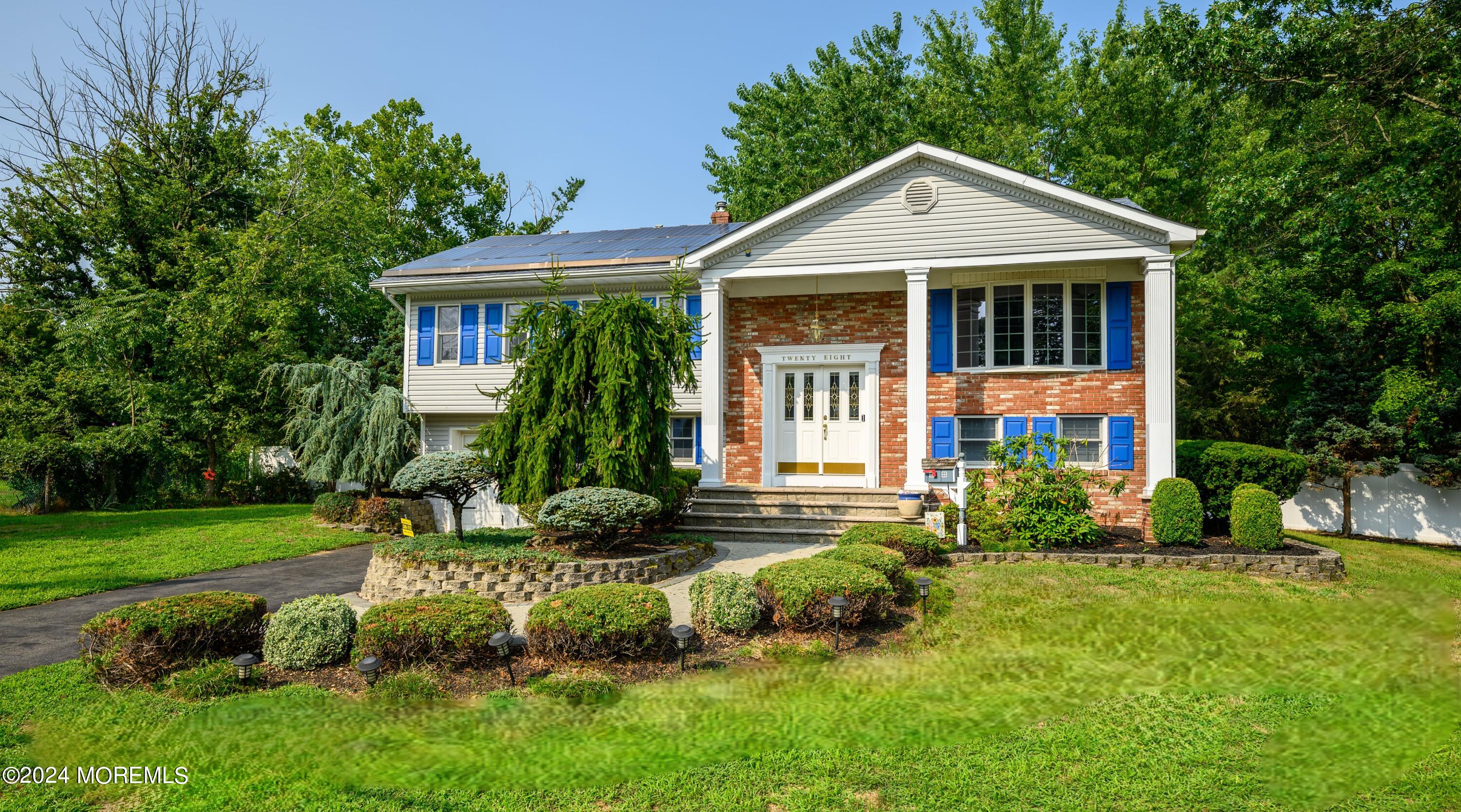 a front view of a house with a yard and trees