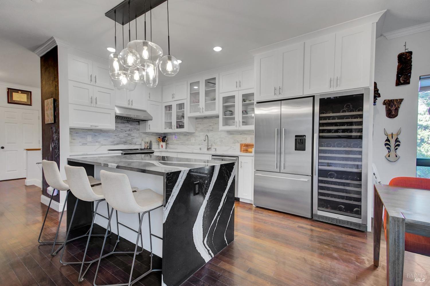 a kitchen with kitchen island granite countertop a sink cabinets and stainless steel appliances