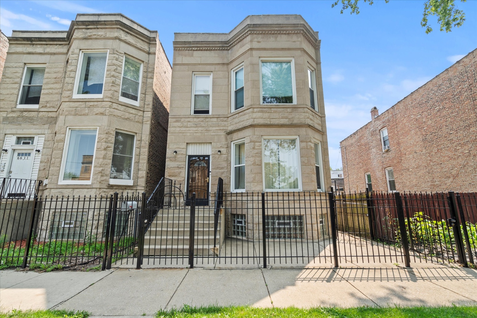 front view of a brick house with a iron gate