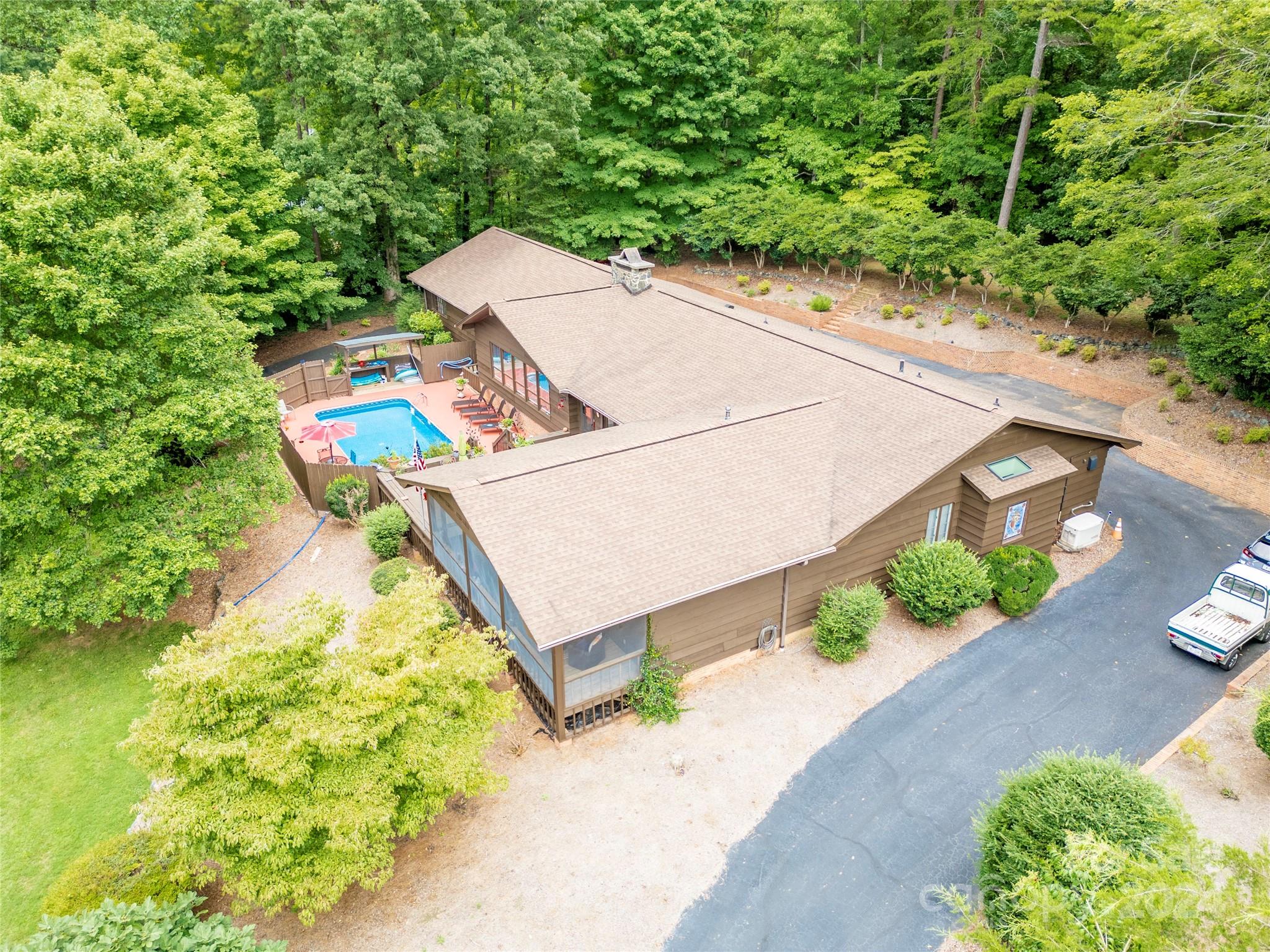 an aerial view of a house with a yard and lake