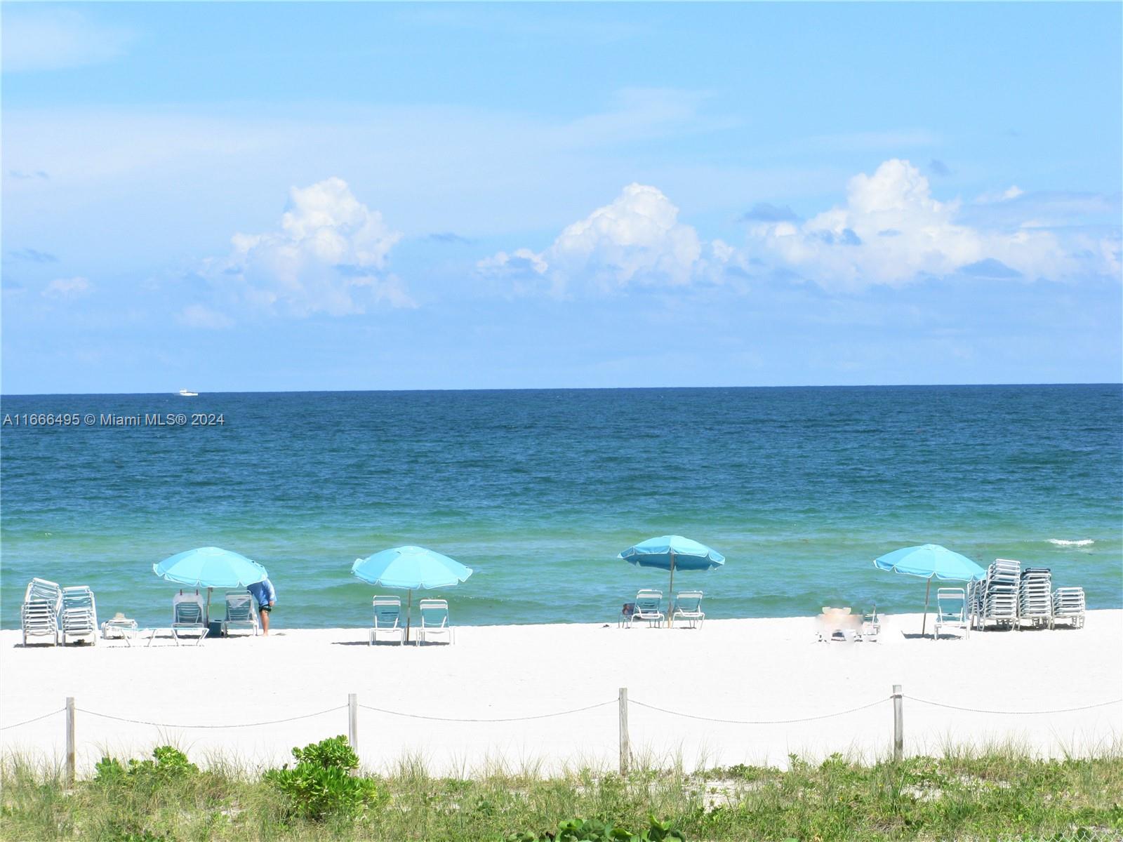 a view of ocean with lots of car parked