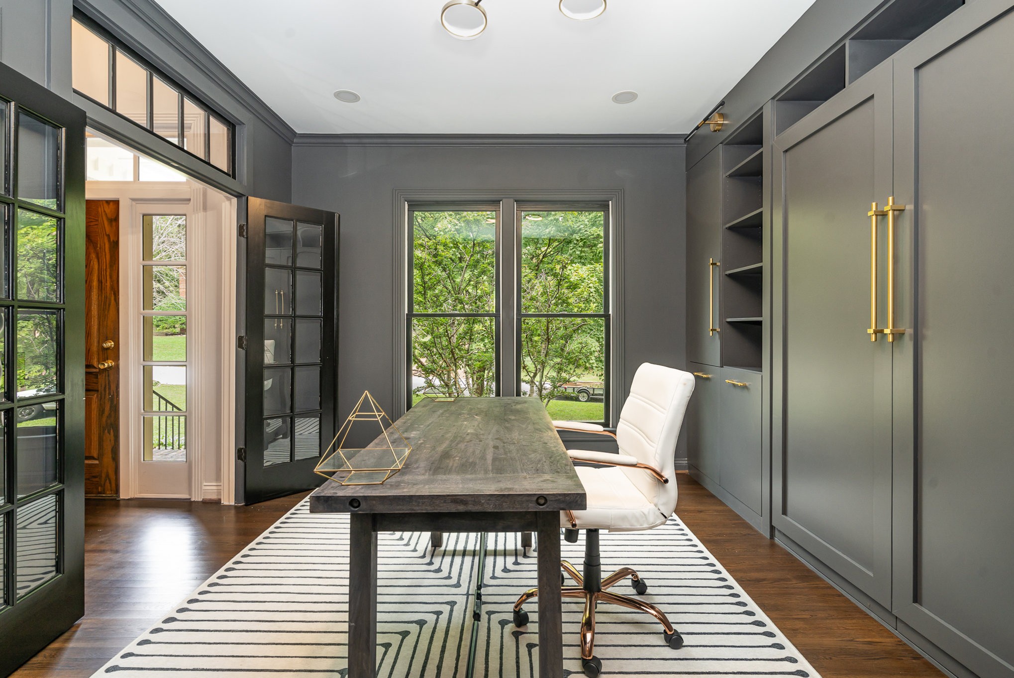 a view of a hallway with furniture and wooden floor