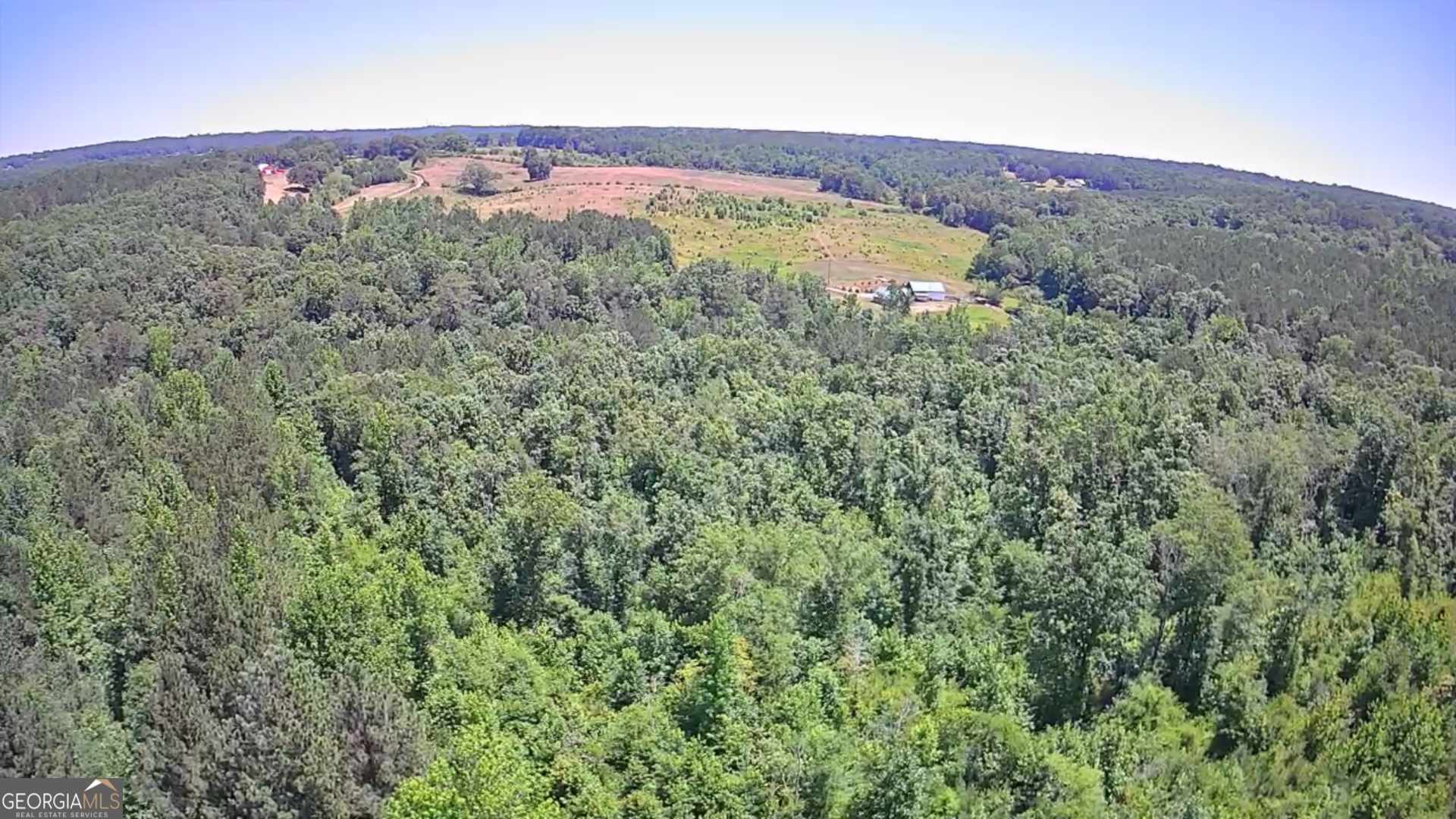 an aerial view of a houses with a lush green hillside