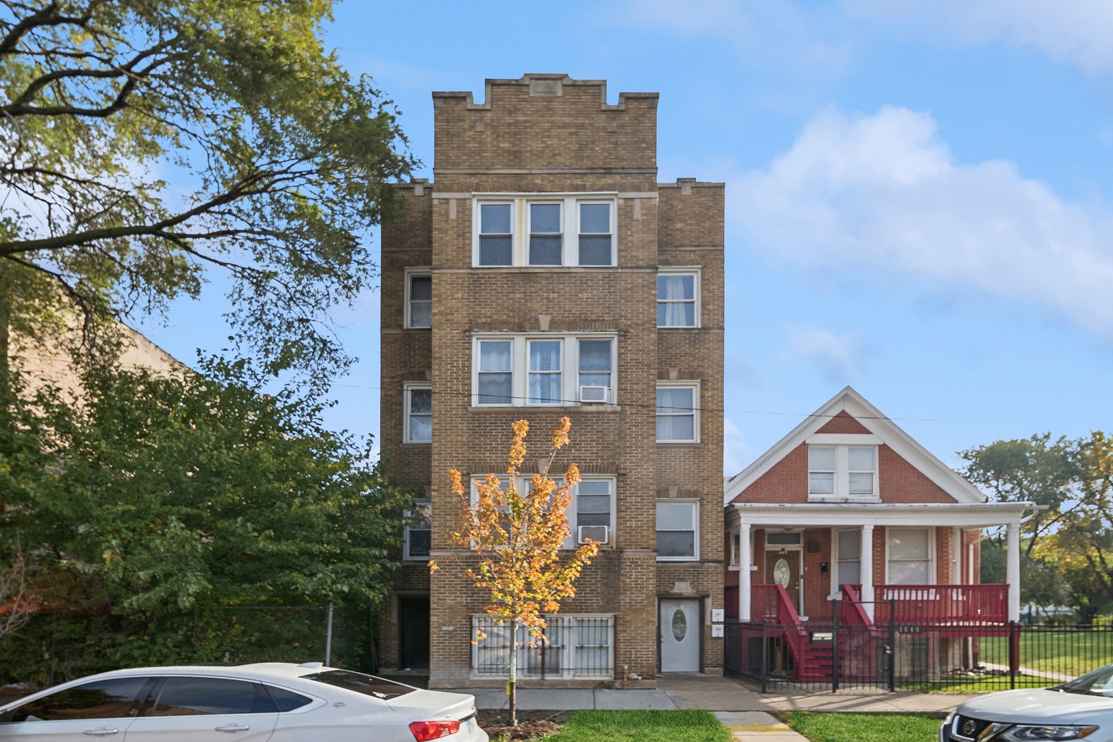 a front view of a residential apartment building with a yard