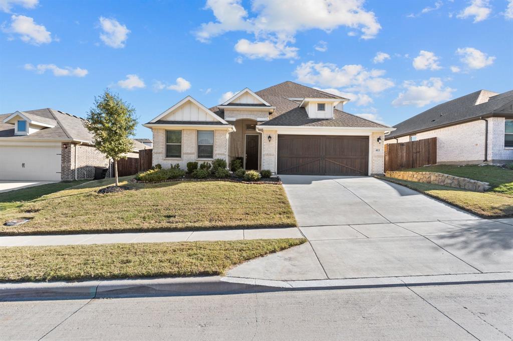 View of front of property featuring a front yard and a garage