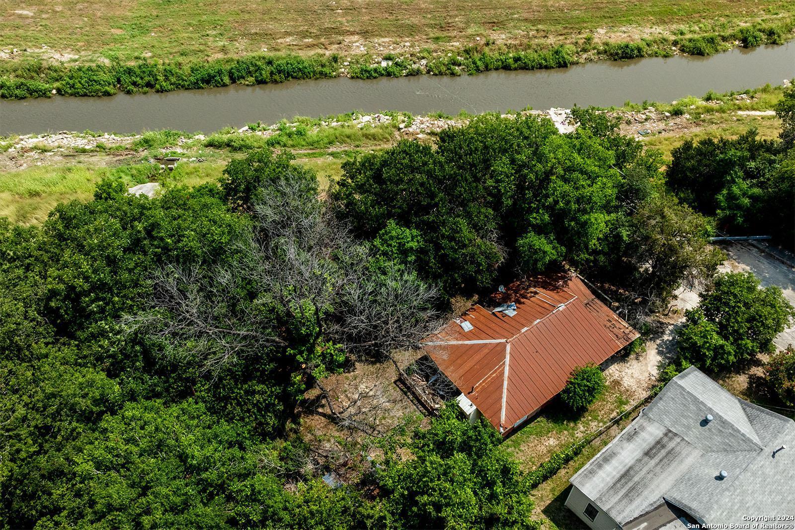 an aerial view of a house with garden space and lake view