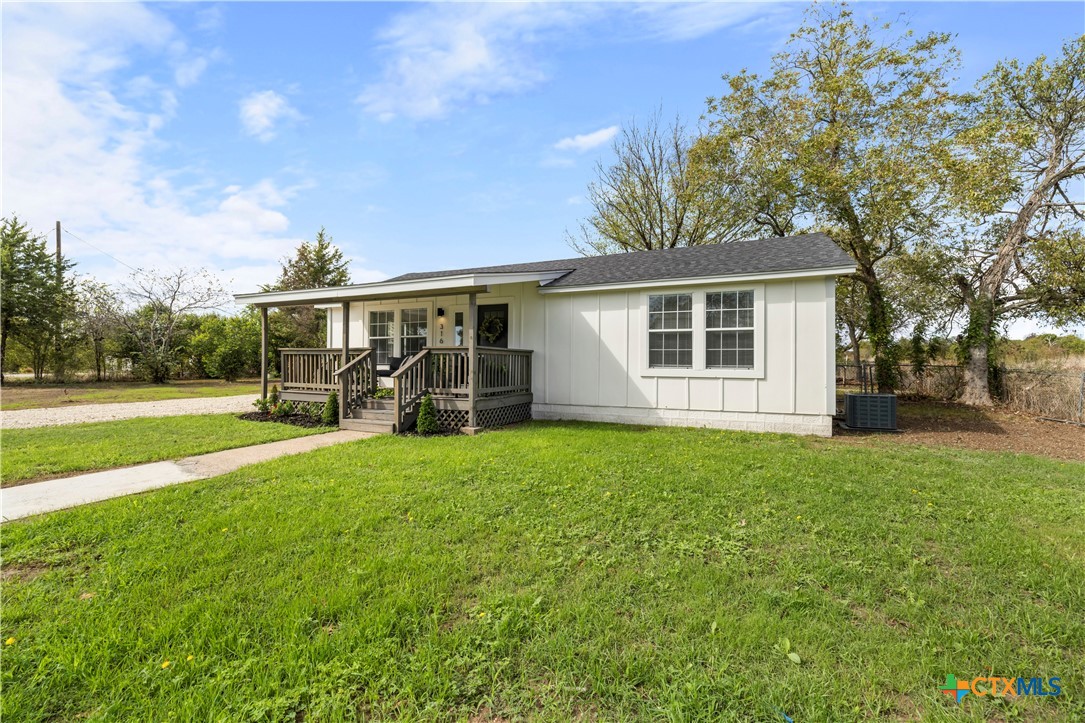 a view of a house with backyard and a tree