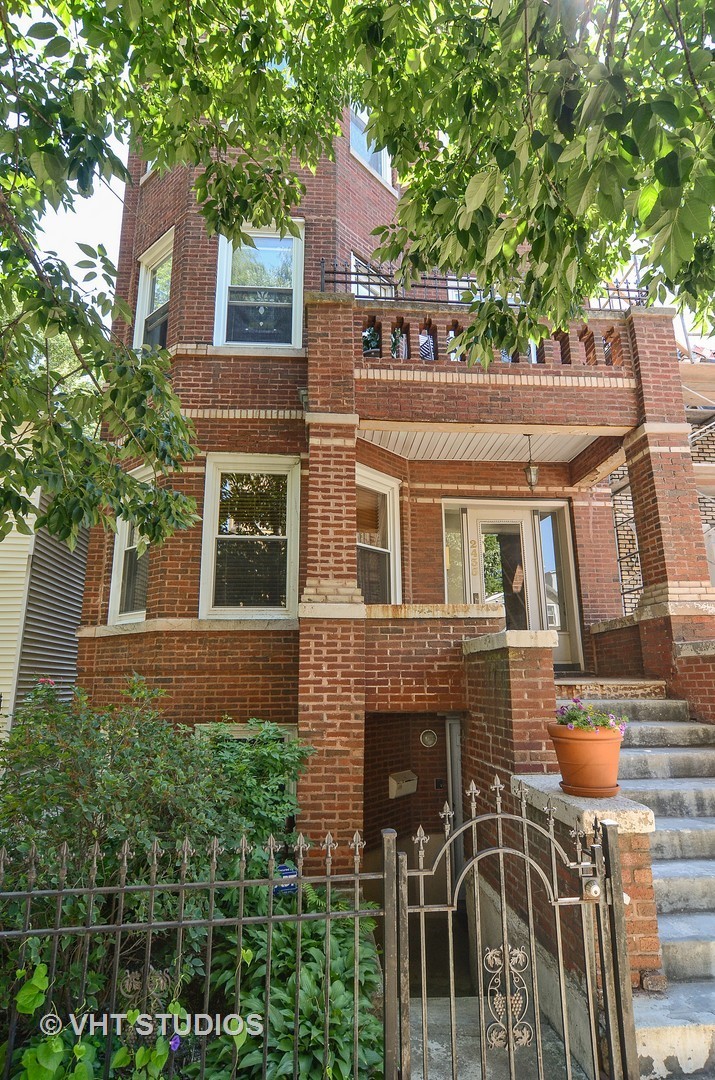 a front view of a house with glass windows and plants