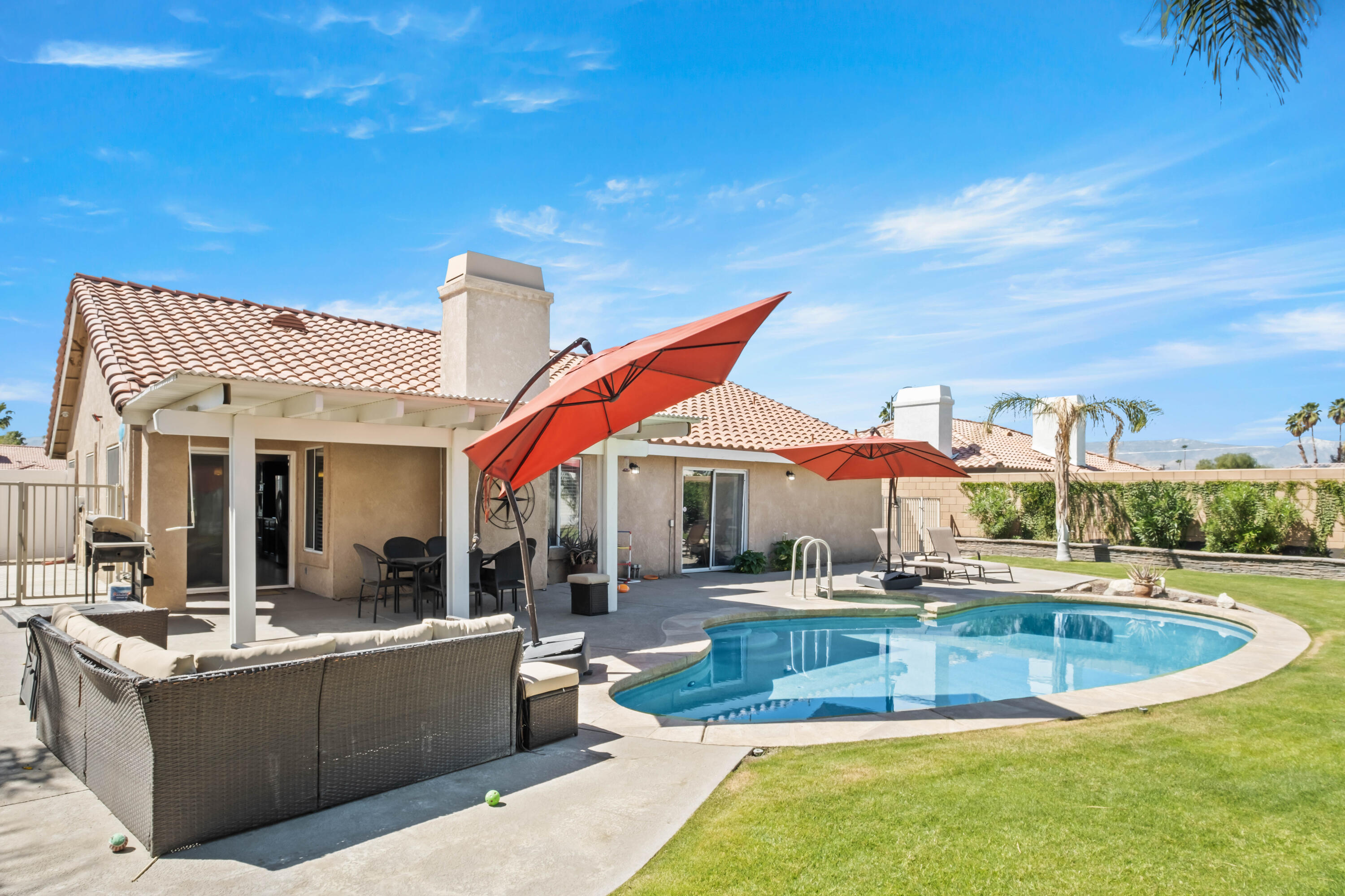 a view of a house with swimming pool and sitting area