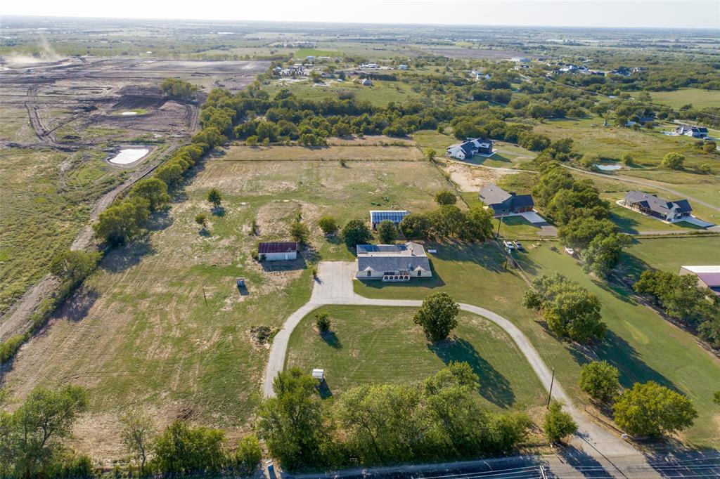 an aerial view of residential houses with outdoor space and trees