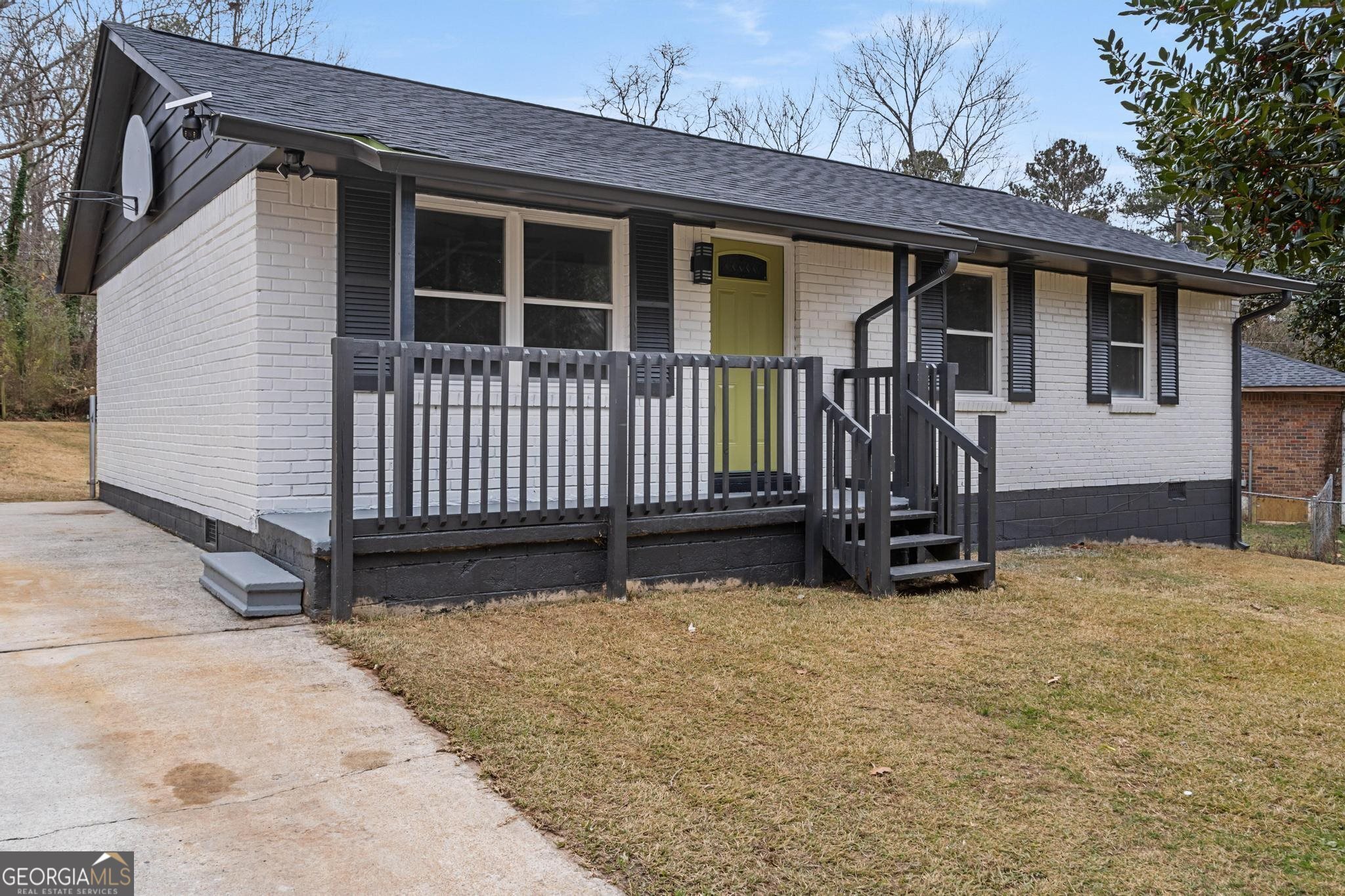 a view of a house with a yard and wooden fence