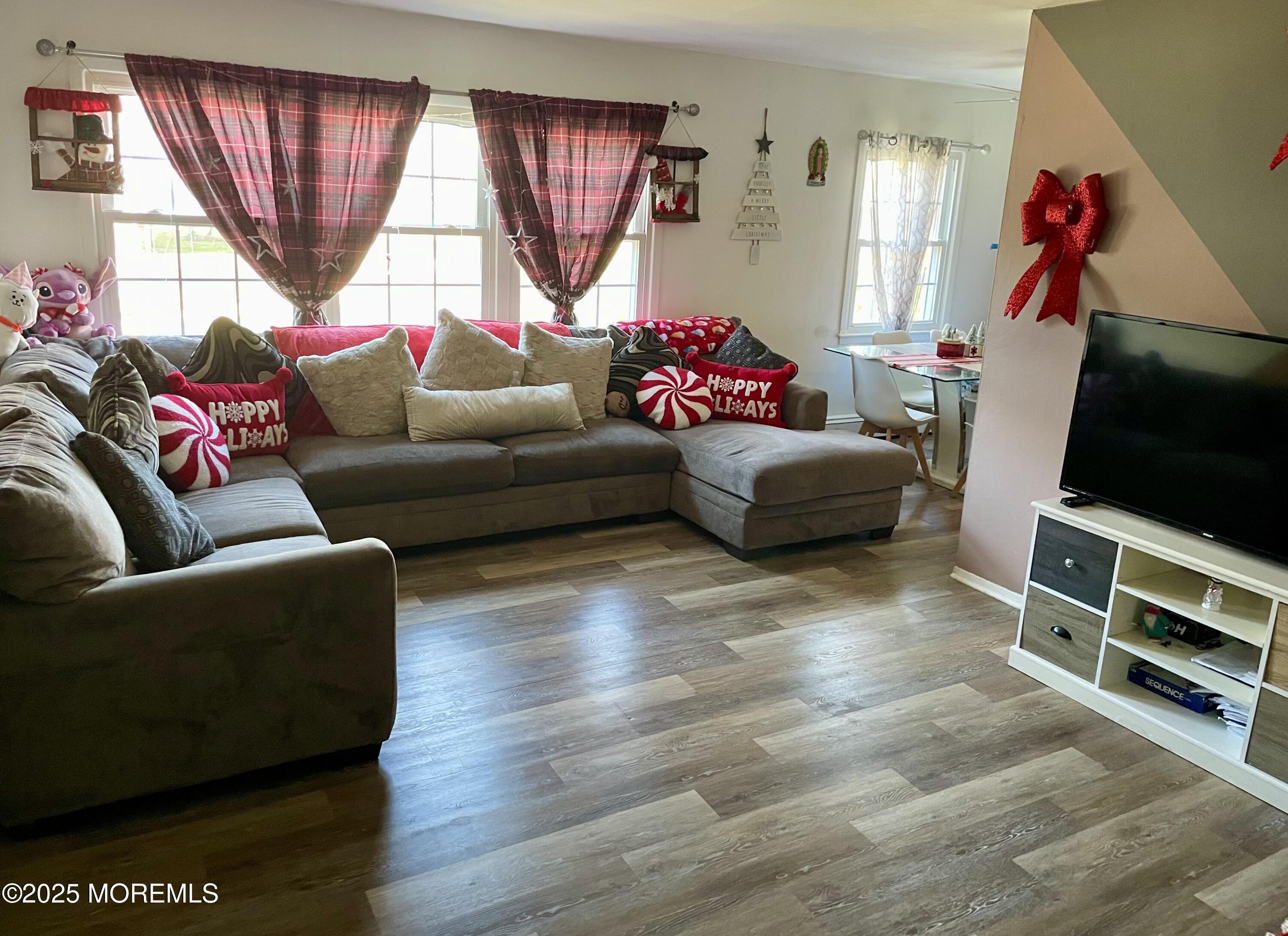 a living room with furniture a flat screen tv and a window