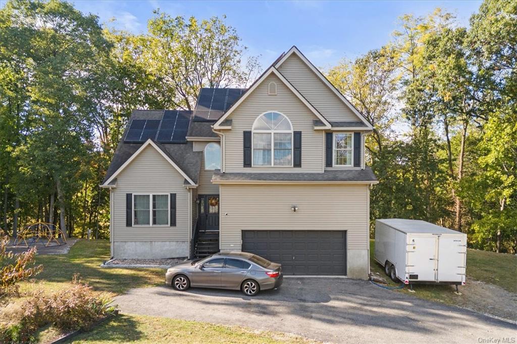 a front view of a house with cars parked