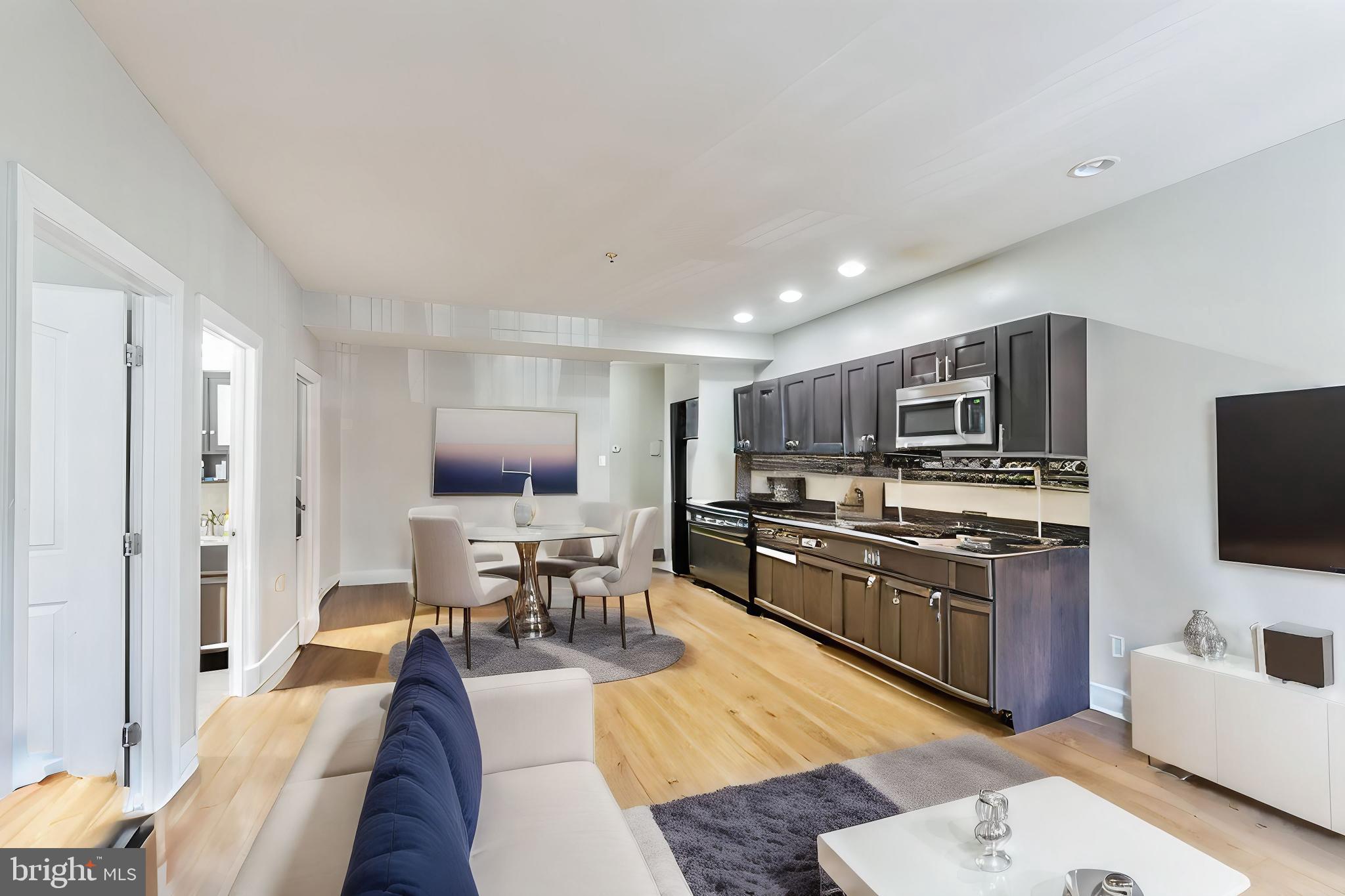 a living room with furniture kitchen view and a window