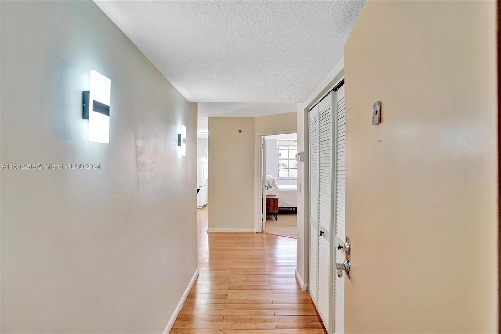 a view of a room with wooden floor windows and a bathroom