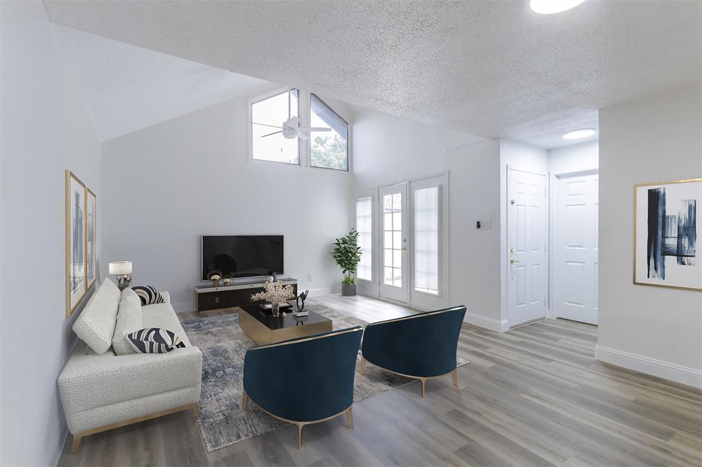 Living room with a textured ceiling, ceiling fan, wood-type flooring, and french doors