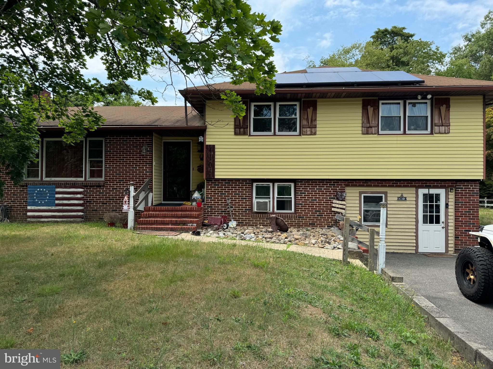 a front view of a house with a garden and yard