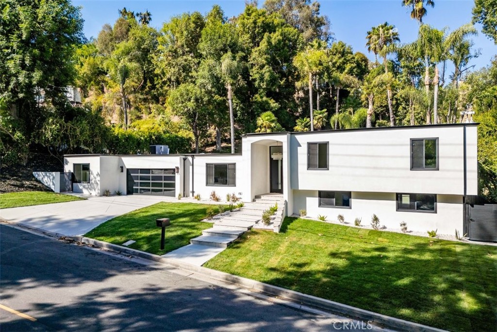 a view of a house with backyard and a tree