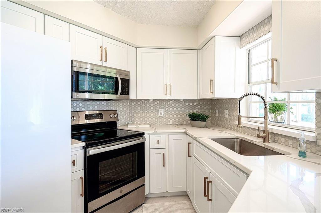 a kitchen with a sink stove top oven and microwave