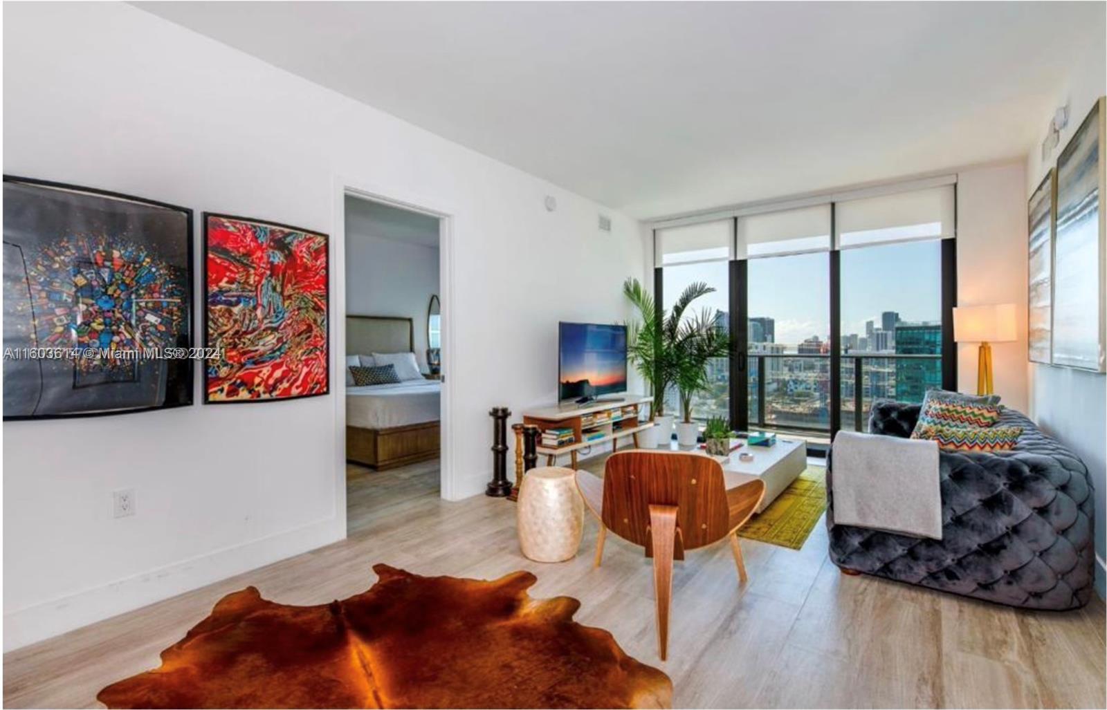 a living room with furniture fireplace and large window