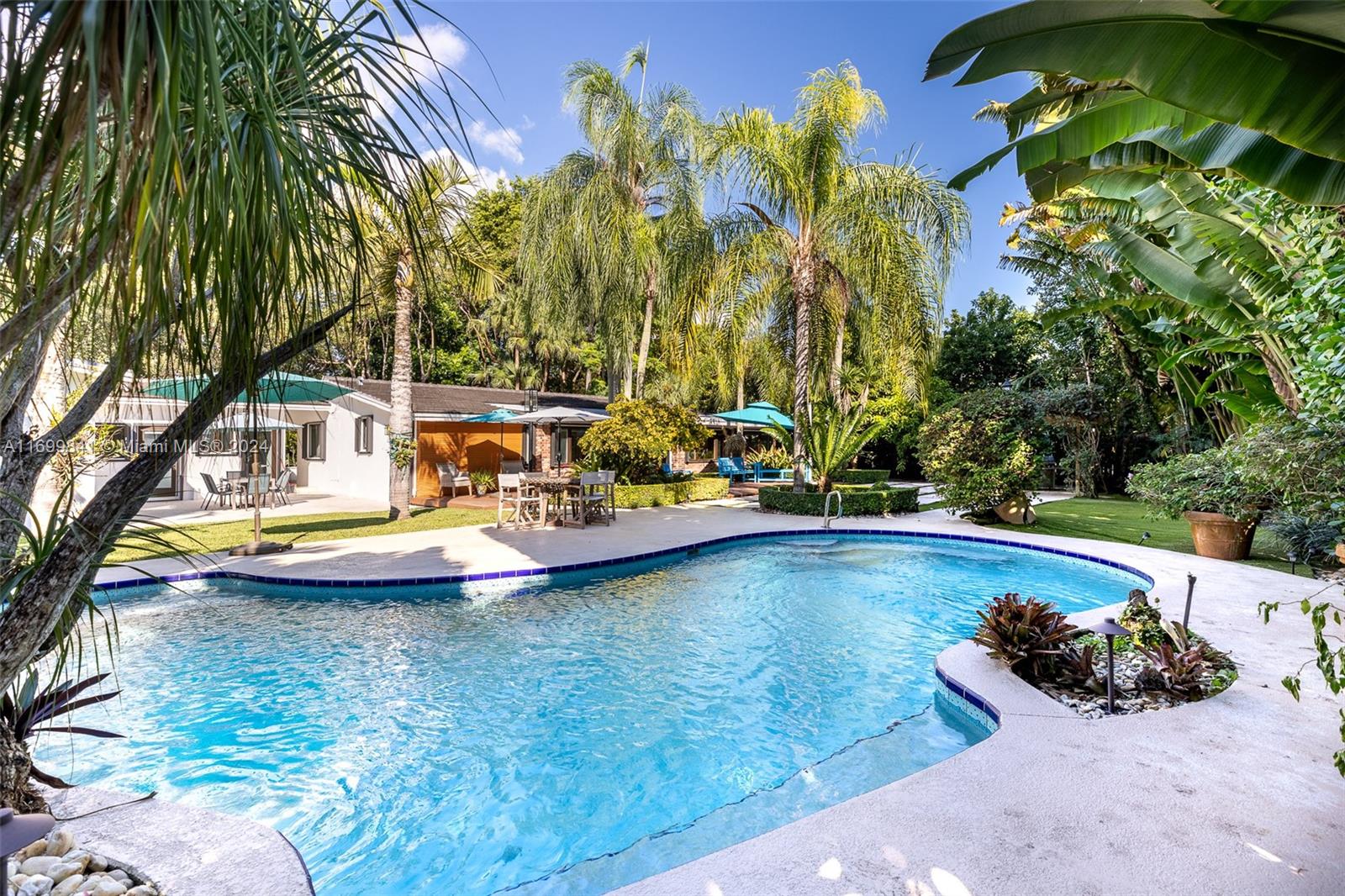 a view of a swimming pool with a lawn chairs under an umbrella