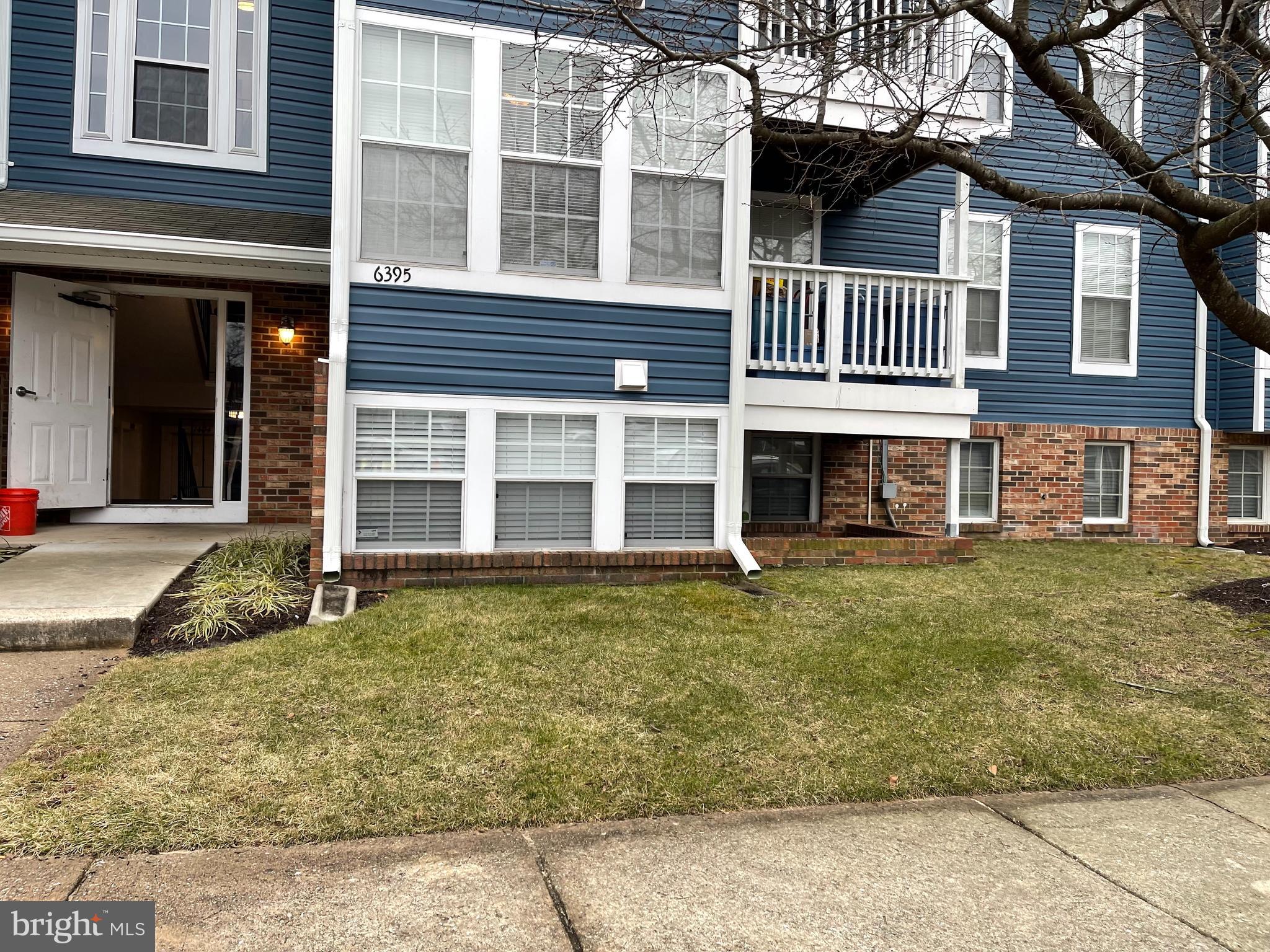 front view of a brick house with a yard