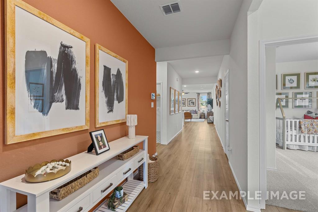 a view of a hallway with wooden floor and furniture