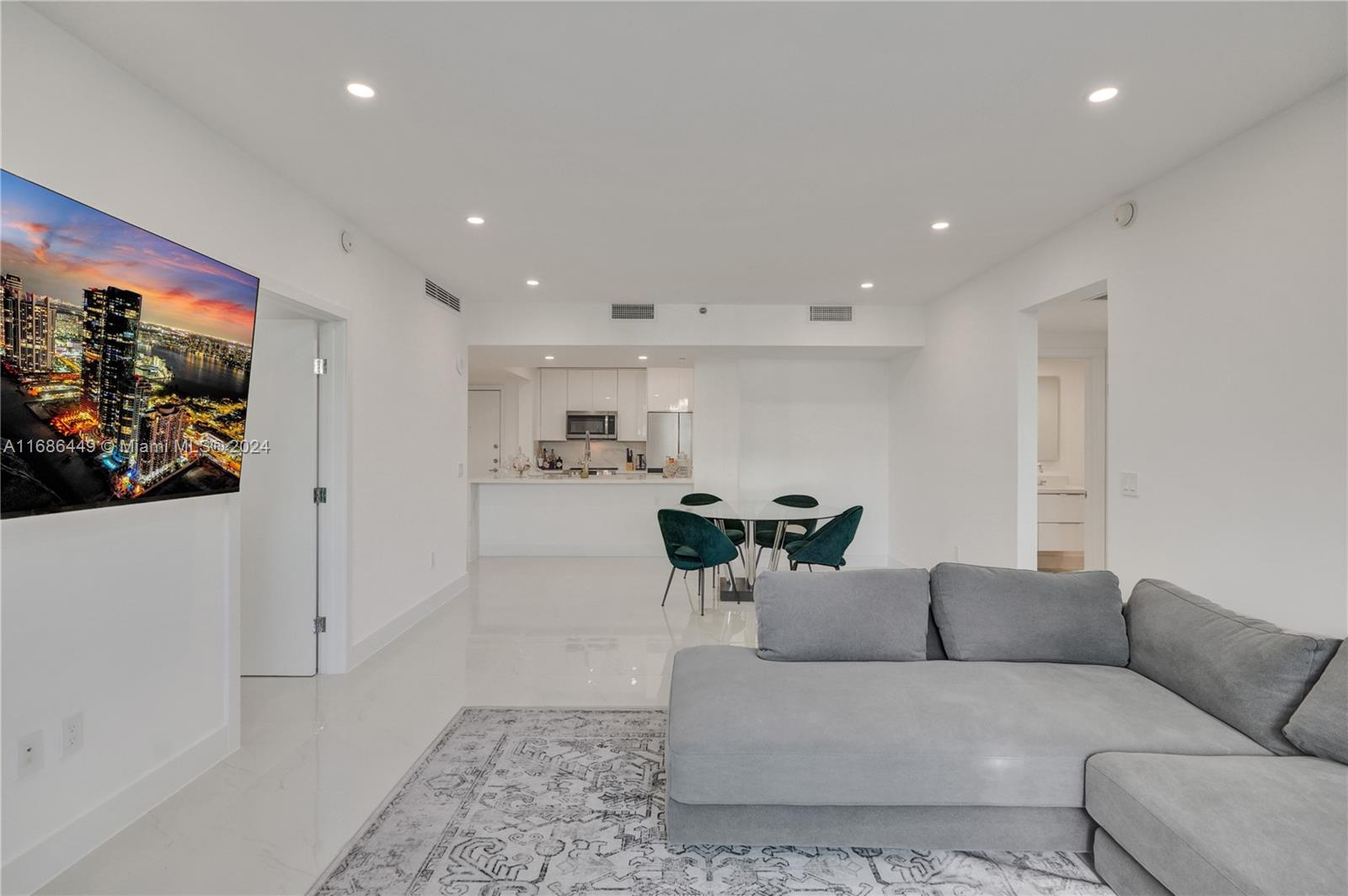 a living room with furniture and a view of kitchen