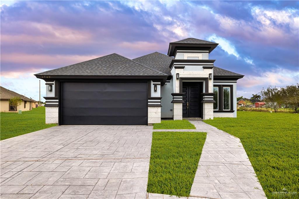 a front view of a house with a yard and a garage