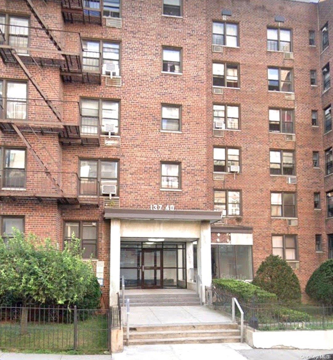 a front view of a building with a garden and plants