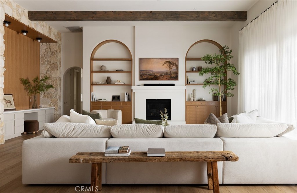 a living room with furniture a fireplace and a dining table with wooden floor