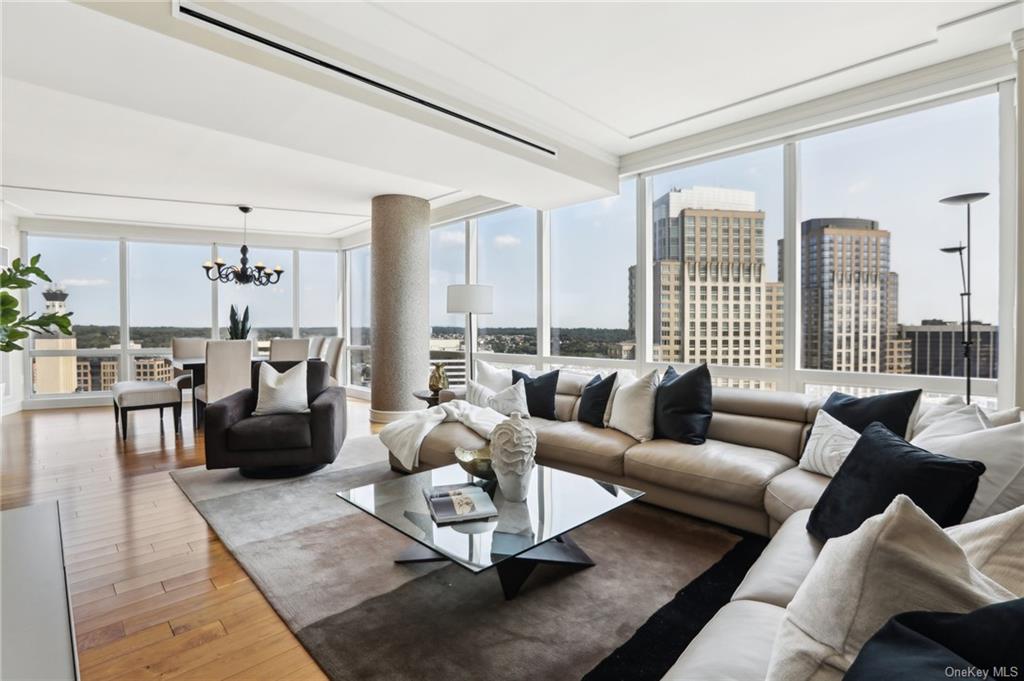 Living room with expansive windows, a chandelier, and hardwood / wood-style flooring