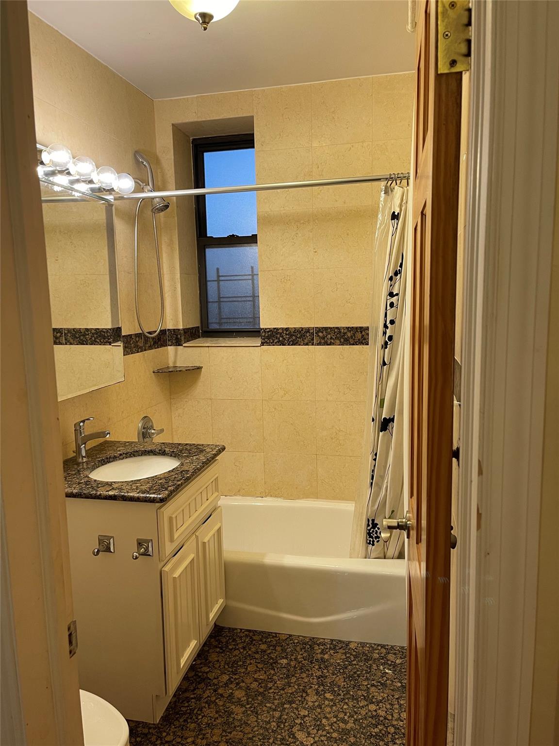 Full bathroom featuring shower / tub combo, vanity, and toilet