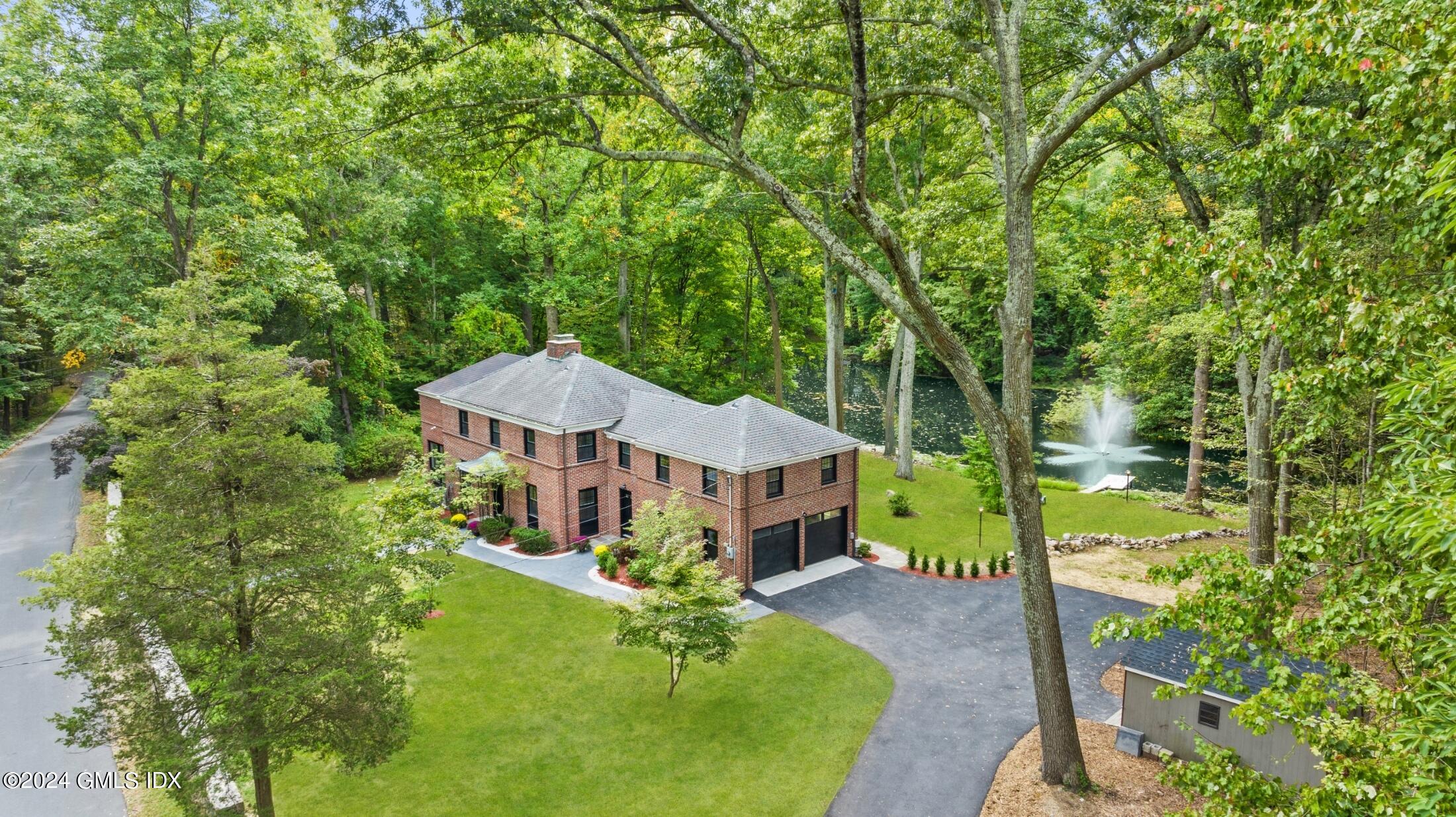 a aerial view of a house with large trees and plants