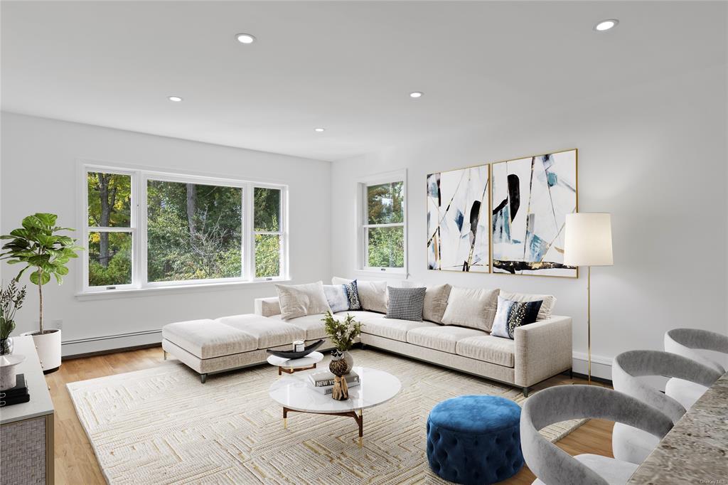 Living room featuring a baseboard heating unit and light hardwood / wood-style flooring